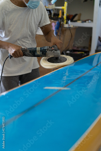 Man repairs surfboard, hands close up, Surfboard Workshop in Bali