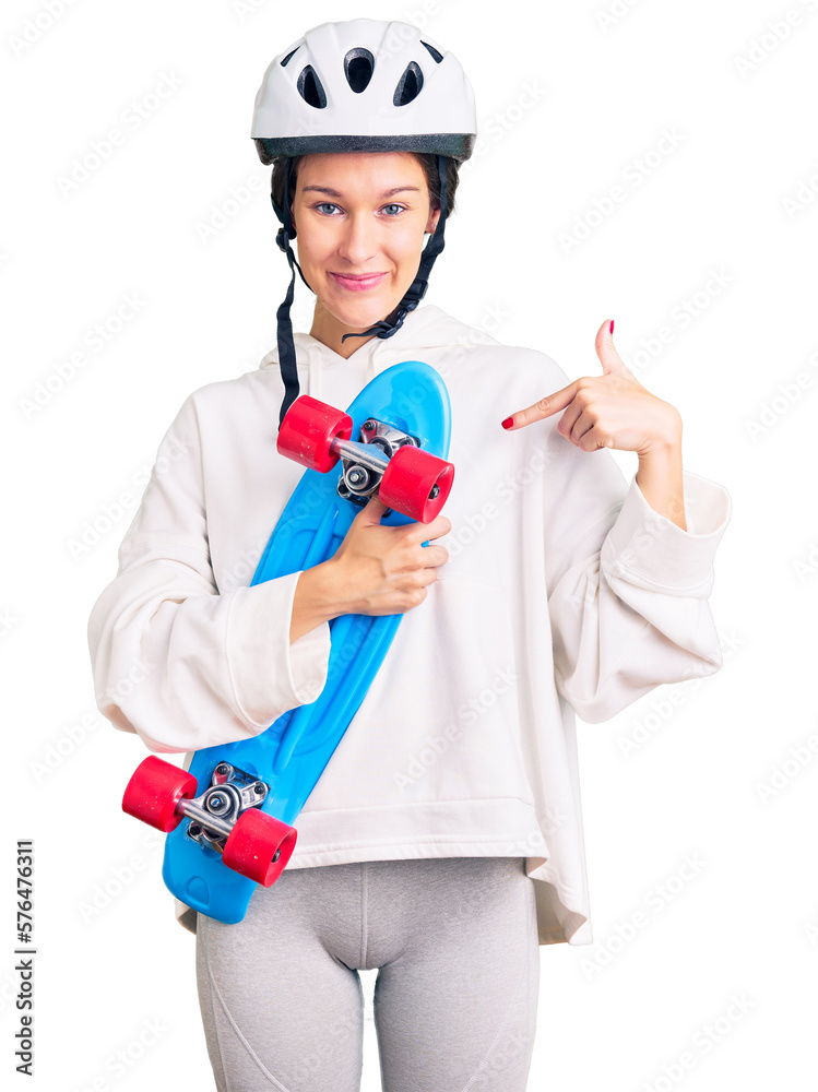 Beautiful brunette young woman wearing safety helmet and skate pointing finger to one self smiling happy and proud Beautiful brunette young woman wearing safety helmet and skate pointing finger to one self smiling happy and proud