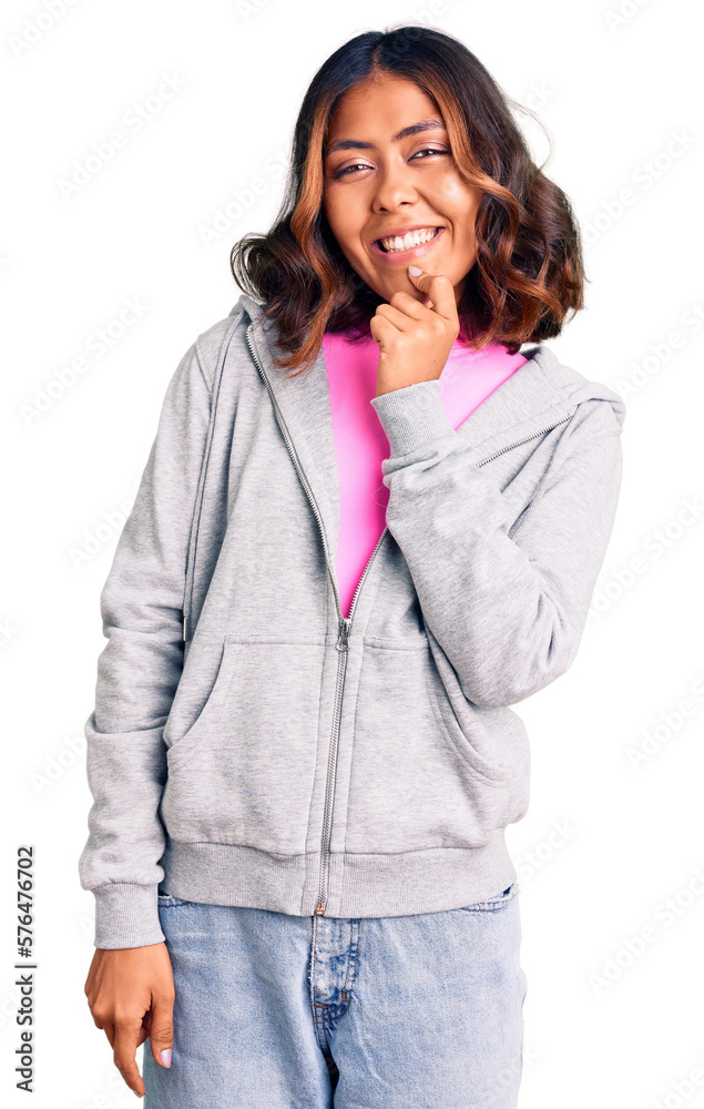 Young beautiful mixed race woman wearing casual sporty clothes looking confident at the camera with smile with crossed arms and hand raised on chin. thinking positive. Young beautiful mixed race woman wearing casual sporty clothes looking confident at the camera with smile with crossed arms and hand raised on chin. thinking positive.
