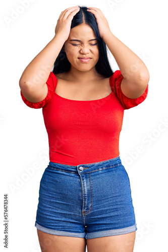 Young beautiful asian girl wearing casual clothes suffering from headache desperate and stressed because pain and migraine. hands on head.