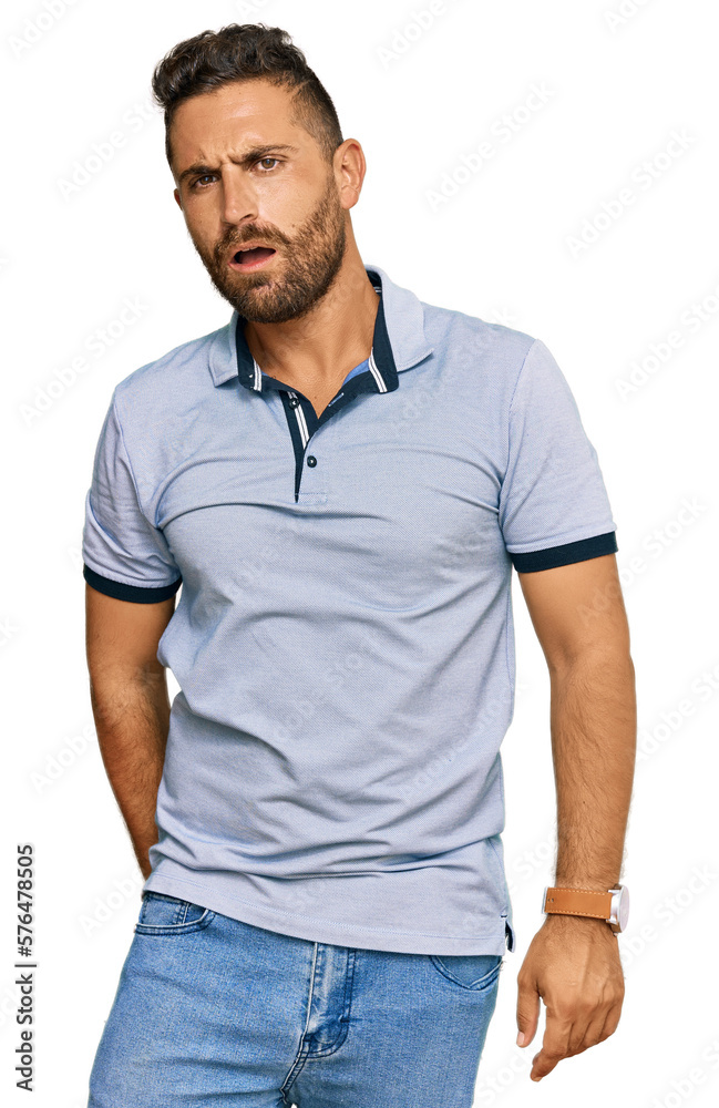 Handsome man with beard wearing casual clothes in shock face, looking skeptical and sarcastic, surprised with open mouth Handsome man with beard wearing casual clothes in shock face, looking skeptical and sarcastic, surprised with open mouth