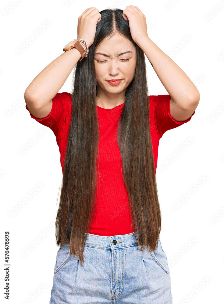 Young chinese woman wearing casual clothes suffering from headache desperate and stressed because pain and migraine. hands on head. Young chinese woman wearing casual clothes suffering from headache desperate and stressed because pain and migraine. hands on head.