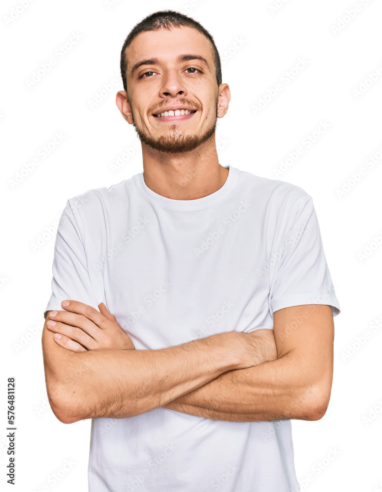 Hispanic young man wearing casual white t shirt happy face smiling with crossed arms looking at the camera. positive person. Hispanic young man wearing casual white t shirt happy face smiling with crossed arms looking at the camera. positive person.
