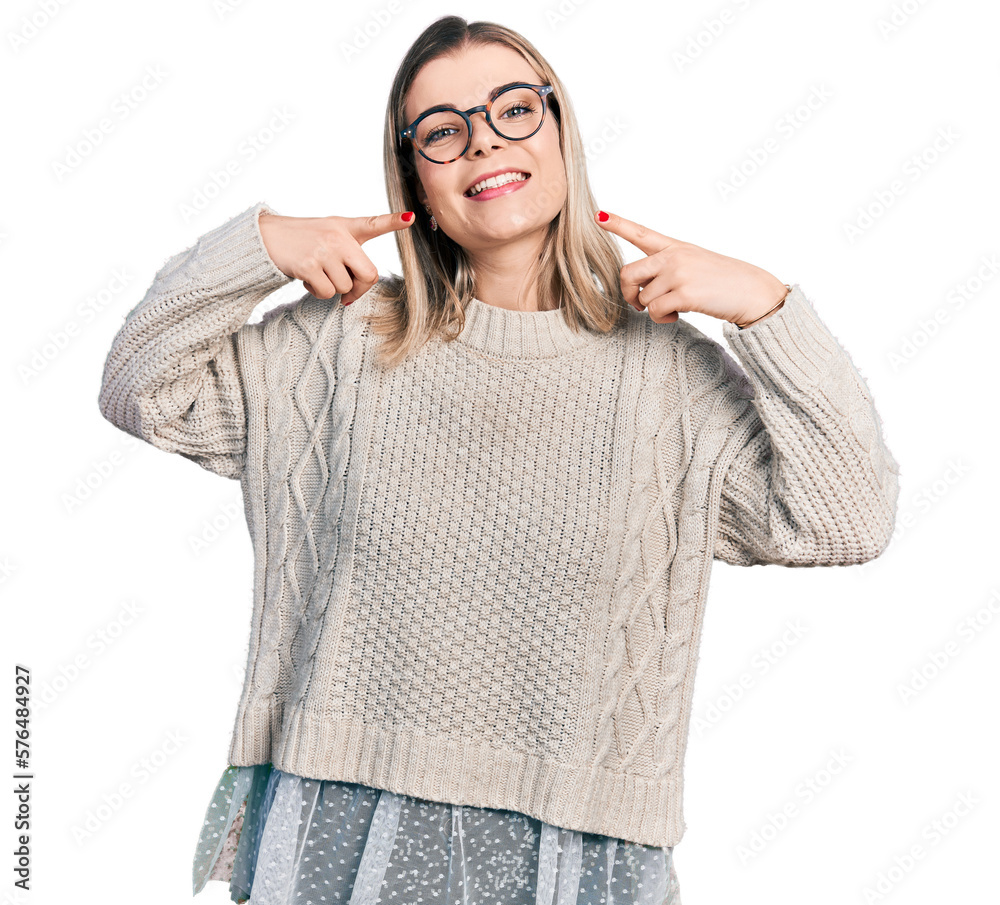 Young blonde woman wearing glasses smiling cheerful showing and pointing with fingers teeth and mouth. dental health concept. Young blonde woman wearing glasses smiling cheerful showing and pointing with fingers teeth and mouth. dental health concept.