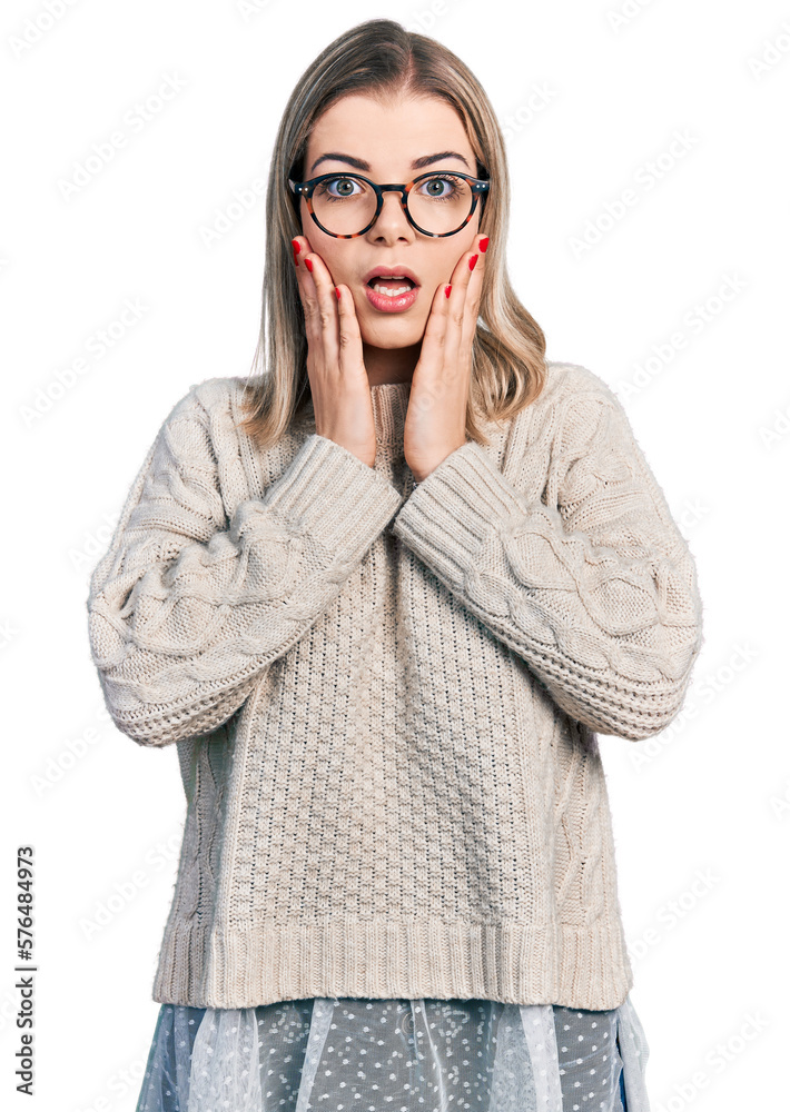 Young blonde woman wearing glasses afraid and shocked, surprise and amazed expression with hands on face Young blonde woman wearing glasses afraid and shocked, surprise and amazed expression with hands on face