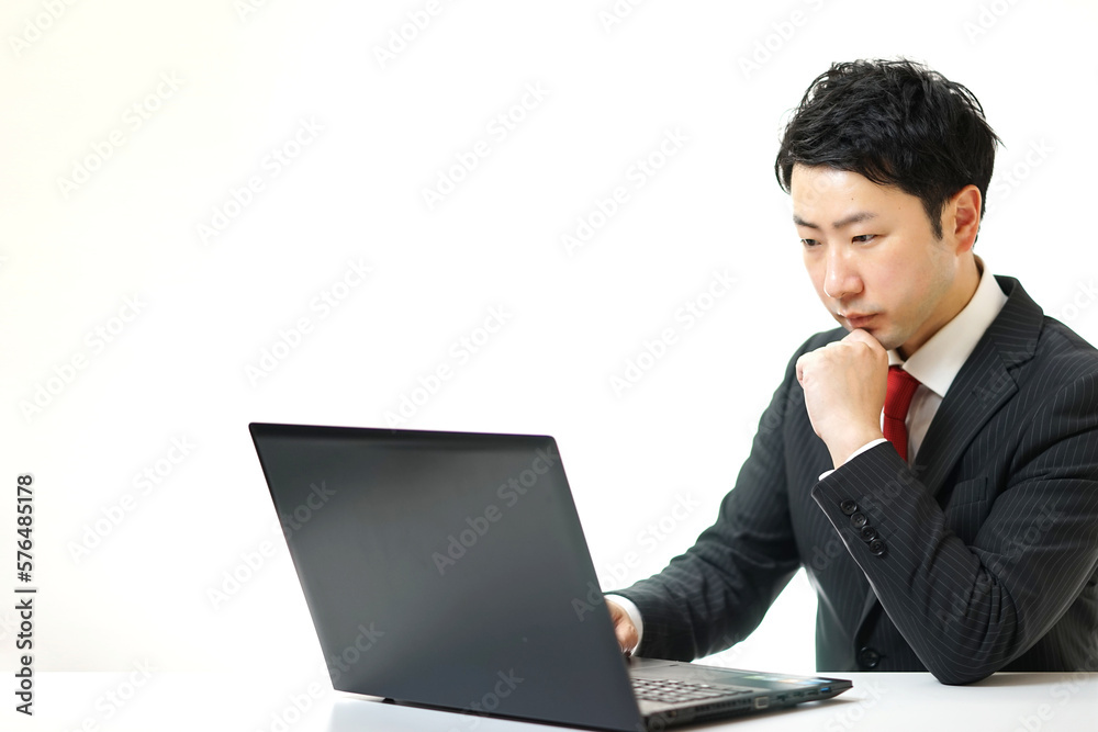 PCを見て考えているビジネスマン PCを見て考えているビジネスマン