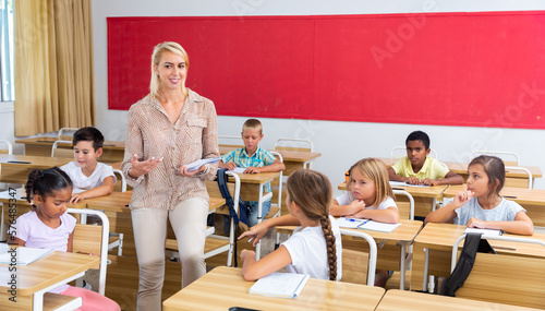 Female teacher talking with primary school pupils in classroom