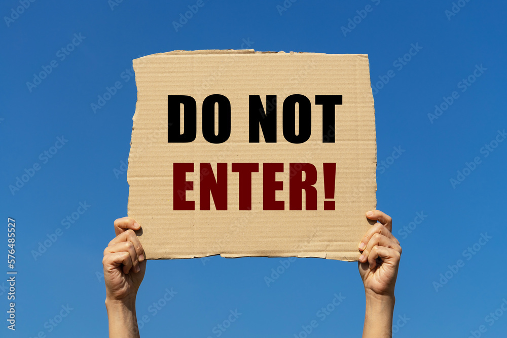 Do not enter text on box paper held by 2 hands with isolated blue sky background. This message board can be used as business concept to inform everyone that this area is restrcited. Do not enter text on box paper held by 2 hands with isolated blue sky background. This message board can be used as business concept to inform everyone that this area is restrcited.