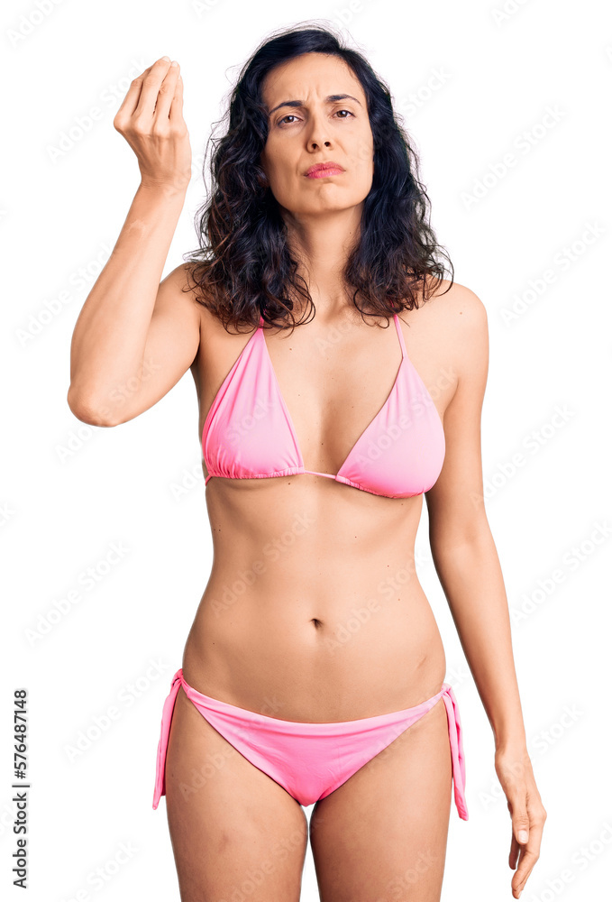 Young beautiful hispanic woman wearing bikini doing italian gesture with hand and fingers confident expression Young beautiful hispanic woman wearing bikini doing italian gesture with hand and fingers confident expression