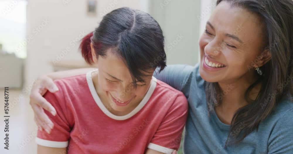 Portrait of happy biracial sisters embracing and smiling in garden, in slow motion Portrait of happy biracial sisters embracing and smiling in garden, in slow motion