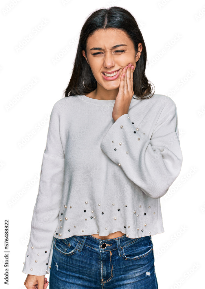 Young hispanic girl wearing casual clothes touching mouth with hand with painful expression because of toothache or dental illness on teeth. dentist Young hispanic girl wearing casual clothes touching mouth with hand with painful expression because of toothache or dental illness on teeth. dentist