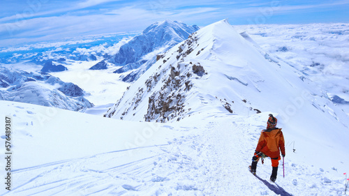 A climber enjoying panoramic view on Mt Denali in Alaska, the highest mountain in North America