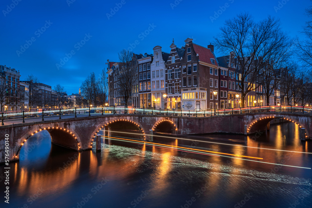 Evening panoramic view of the famous historic center with lights, bridges, canals and traditional Dutch houses in Amsterdam, Netherlands