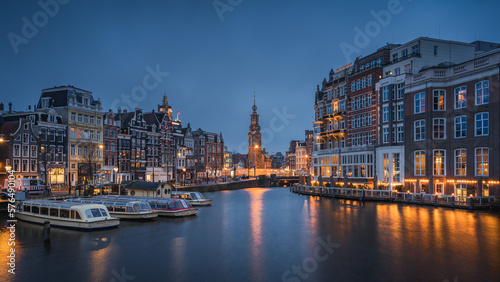 Evening panoramic view of the famous historic center with lights  bridges  canals and traditional Dutch houses in Amsterdam  Netherlands