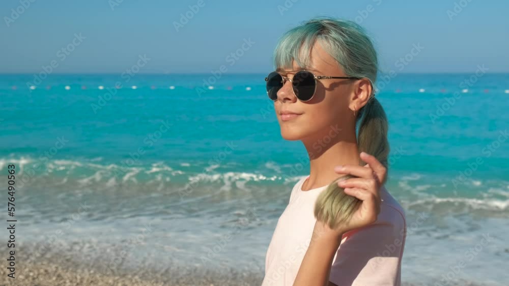 Modern girl in bright sea sunlight. A view of modern hair style teen girl admire the blue ocean waves in the day sunny light. Modern girl in bright sea sunlight. A view of modern hair style teen girl admire the blue ocean waves in the day sunny light.