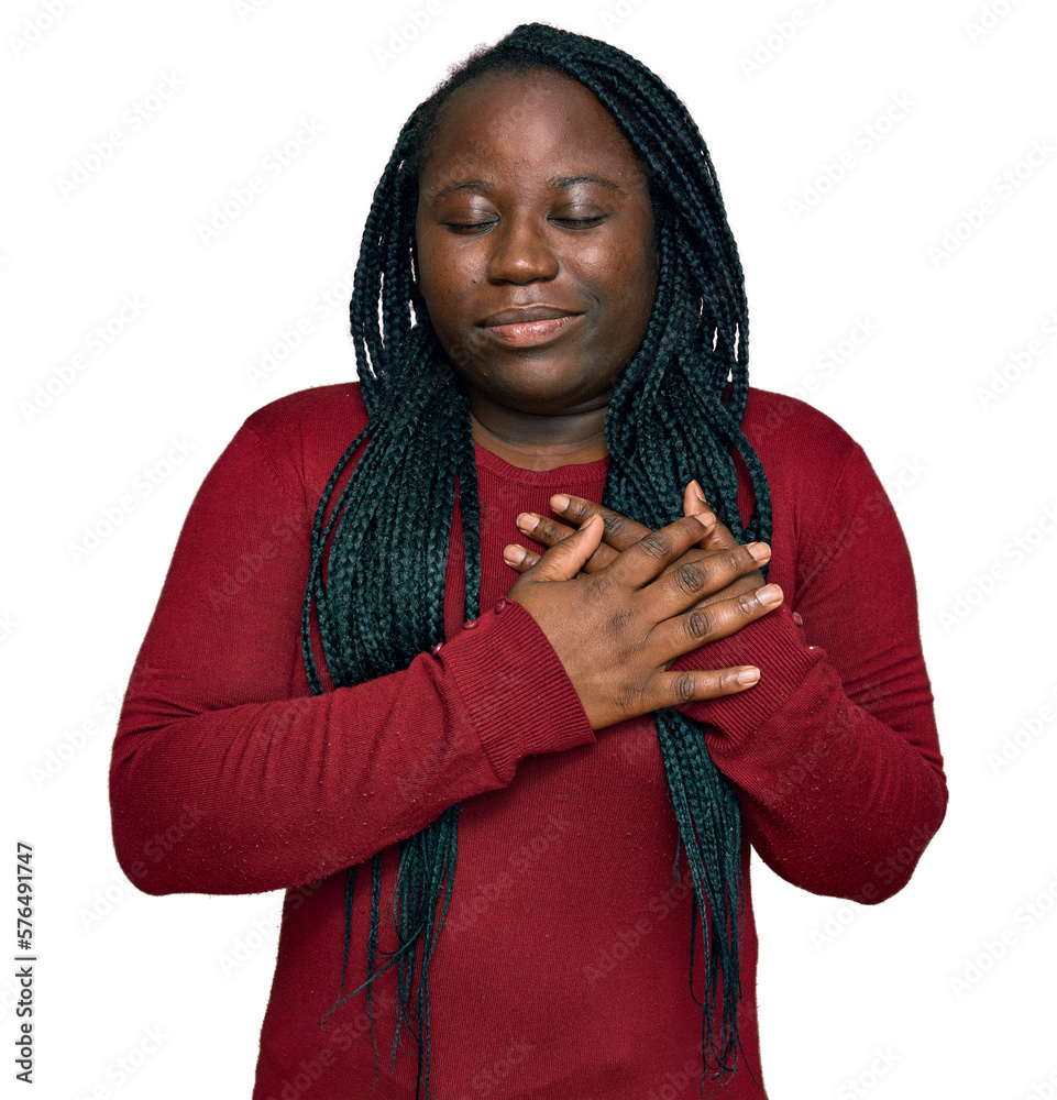 Young black woman with braids wearing casual clothes smiling with hands on chest with closed eyes and grateful gesture on face. health concept. Young black woman with braids wearing casual clothes smiling with hands on chest with closed eyes and grateful gesture on face. health concept.
