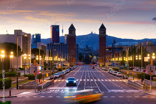 Scenic view of Avinguda de la Reina Maria Cristina in Barcelona leading to Placa de Espana with two Venetian Towers on either side of avenue on background of colorful sky at sunset in summer, Spain photo