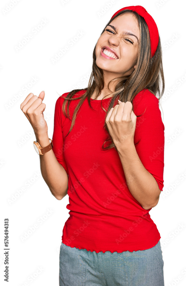 Young brunette woman wearing casual clothes very happy and excited doing winner gesture with arms raised, smiling and screaming for success. celebration concept. Young brunette woman wearing casual clothes very happy and excited doing winner gesture with arms raised, smiling and screaming for success. celebration concept.