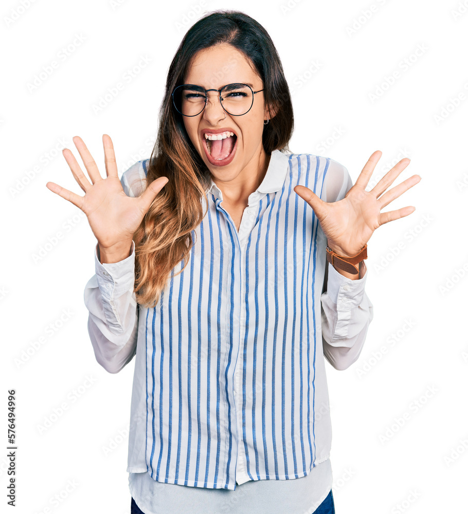 Beautiful hispanic woman wearing casual striped shirt celebrating crazy and amazed for success with arms raised and open eyes screaming excited. winner concept Beautiful hispanic woman wearing casual striped shirt celebrating crazy and amazed for success with arms raised and open eyes screaming excited. winner concept