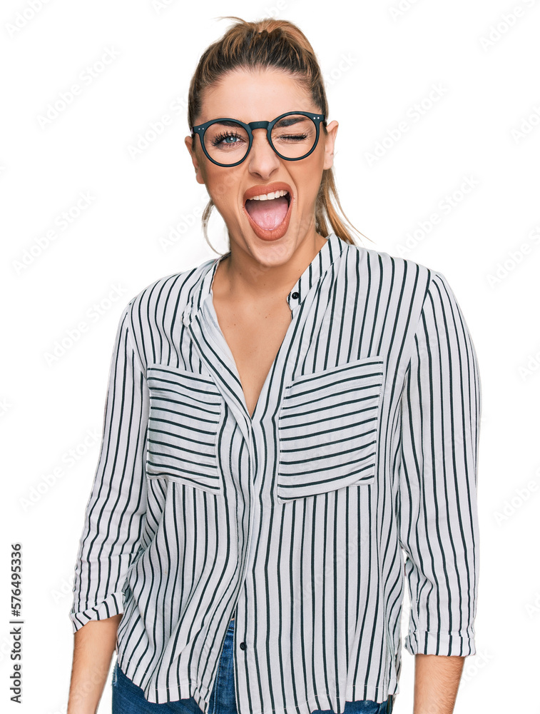 Young caucasian woman wearing business shirt and glasses winking looking at the camera with sexy expression, cheerful and happy face. Young caucasian woman wearing business shirt and glasses winking looking at the camera with sexy expression, cheerful and happy face.