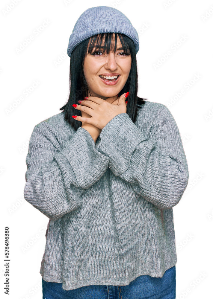 Young hispanic woman wearing cute wool cap shouting and suffocate because painful strangle. health problem. asphyxiate and suicide concept. Young hispanic woman wearing cute wool cap shouting and suffocate because painful strangle. health problem. asphyxiate and suicide concept.
