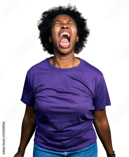 Φωτογραφία African american woman with afro hair wearing casual purple t shirt angry and mad screaming frustrated and furious, shouting with anger
