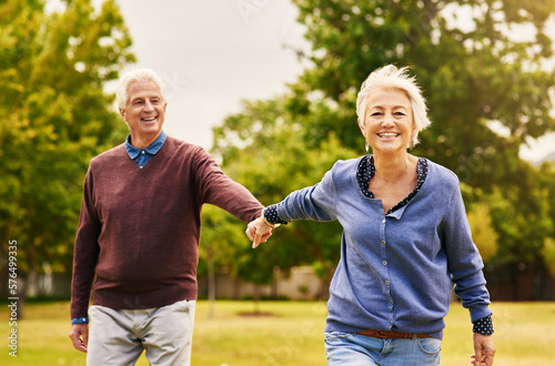 Old couple holding hands  outdoor in park and smile  happiness with freedom in nature  love and retirement. Happy  man and woman with travel  relationship with trust in marriage and commitment