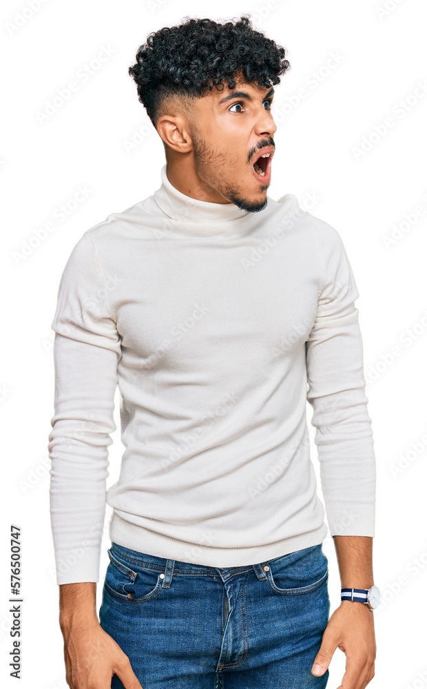 Young arab man wearing casual winter sweater angry and mad screaming frustrated and furious, shouting with anger. rage and aggressive concept. Young arab man wearing casual winter sweater angry and mad screaming frustrated and furious, shouting with anger. rage and aggressive concept.