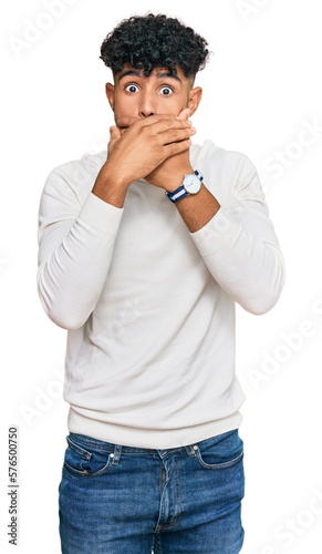 Young arab man wearing casual winter sweater shocked covering mouth with hands for mistake. secret concept.