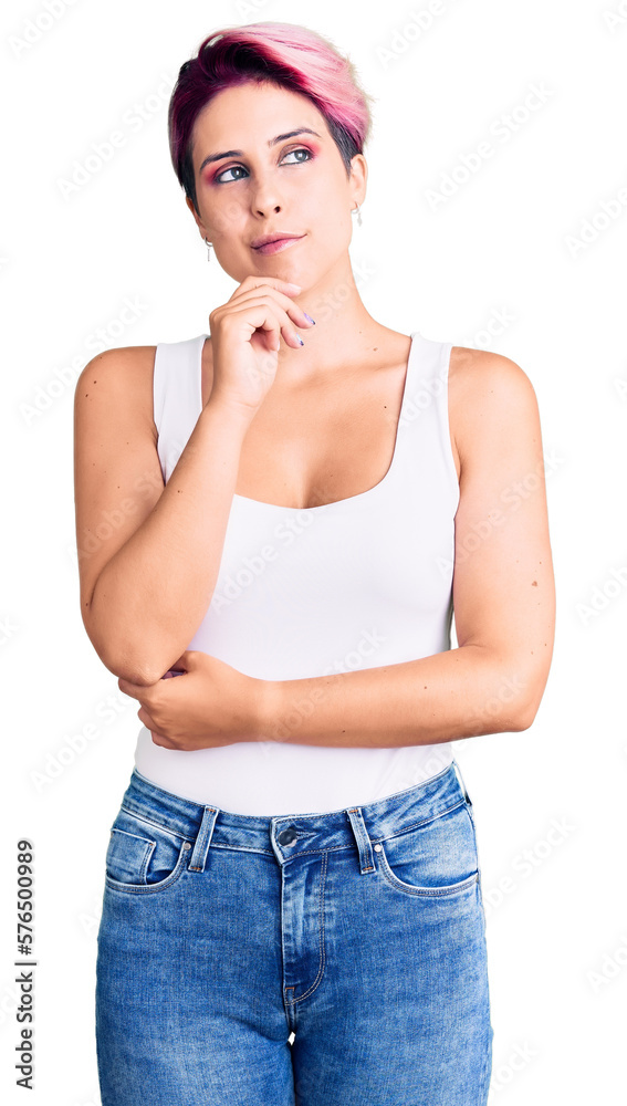 Young beautiful woman with pink hair wearing casual clothes with hand on chin thinking about question, pensive expression. smiling with thoughtful face. doubt concept. Young beautiful woman with pink hair wearing casual clothes with hand on chin thinking about question, pensive expression. smiling with thoughtful face. doubt concept.