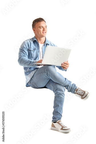 Young man with laptop sitting in chair on white background