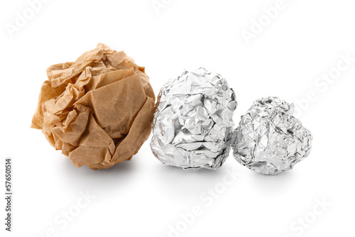 Crumpled balls of aluminium foil and baking paper on white background