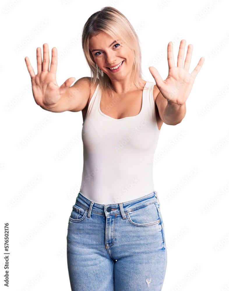 Young beautiful blonde woman wearing casual sleeveless t-shirt showing and pointing up with fingers number ten while smiling confident and happy. Young beautiful blonde woman wearing casual sleeveless t-shirt showing and pointing up with fingers number ten while smiling confident and happy.