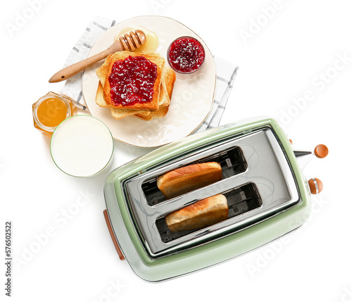 Bread slices in modern toaster, glass of milk, tasty toasts with jam and honey isolated on white background