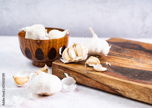 Garlic on a wooden board, white background, text space