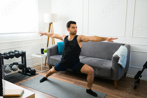 Fototapeta Naklejka Na Ścianę i Meble -  Active sporty man doing yoga in the living room
