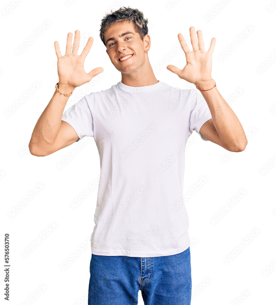 Young handsome man wearing casual white tshirt showing and pointing up with fingers number ten while smiling confident and happy.
