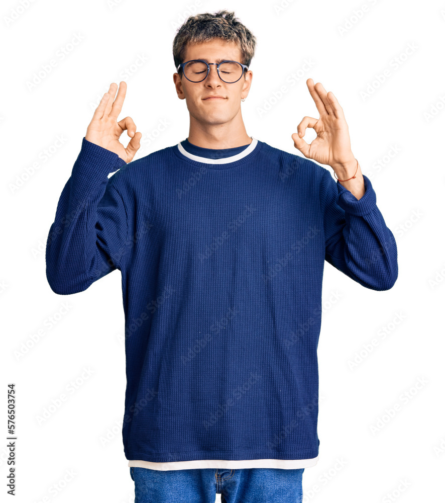 Young handsome man wearing casual clothes and glasses relax and smiling with eyes closed doing meditation gesture with fingers. yoga concept. Young handsome man wearing casual clothes and glasses relax and smiling with eyes closed doing meditation gesture with fingers. yoga concept.