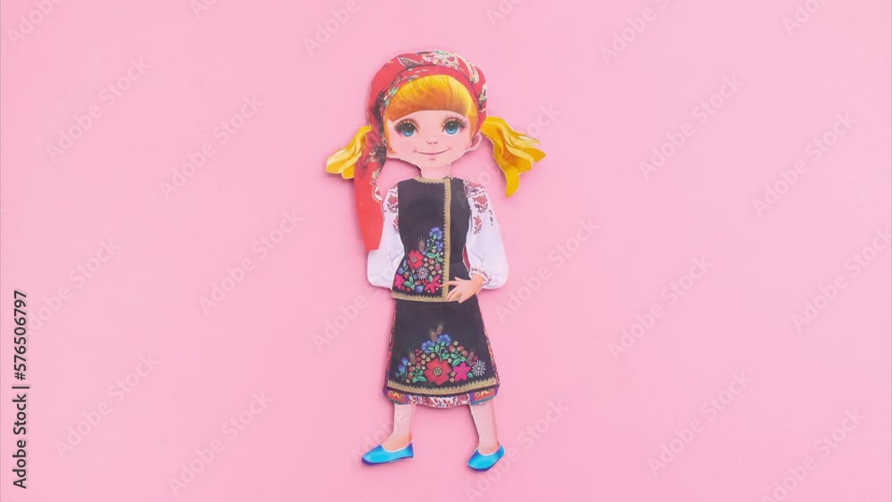 Paper stop motion animation, a paper doll puts on clothes of Ukrainian national colors on a pink background Paper stop motion animation, a paper doll puts on clothes of Ukrainian national colors on a pink background
