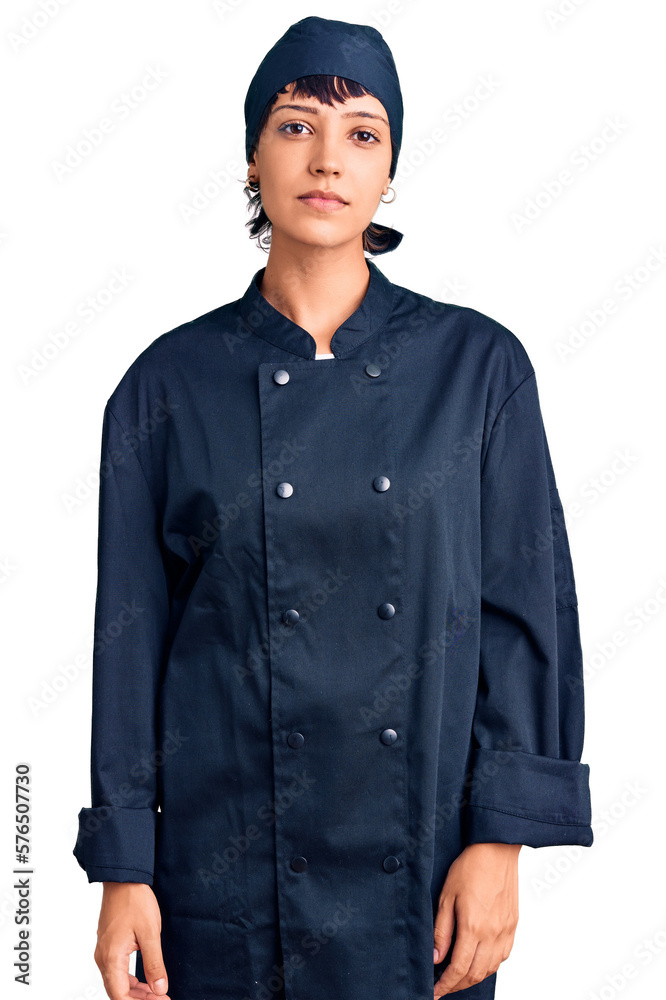 Young brunette woman with short hair wearing professional cook uniform relaxed with serious expression on face. simple and natural looking at the camera. Young brunette woman with short hair wearing professional cook uniform relaxed with serious expression on face. simple and natural looking at the camera.