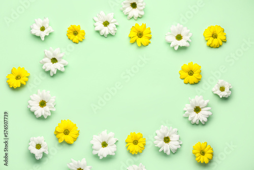 Frame made of white and yellow flowers on color background