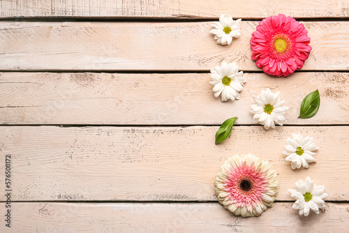 Composition with beautiful flowers on light wooden background