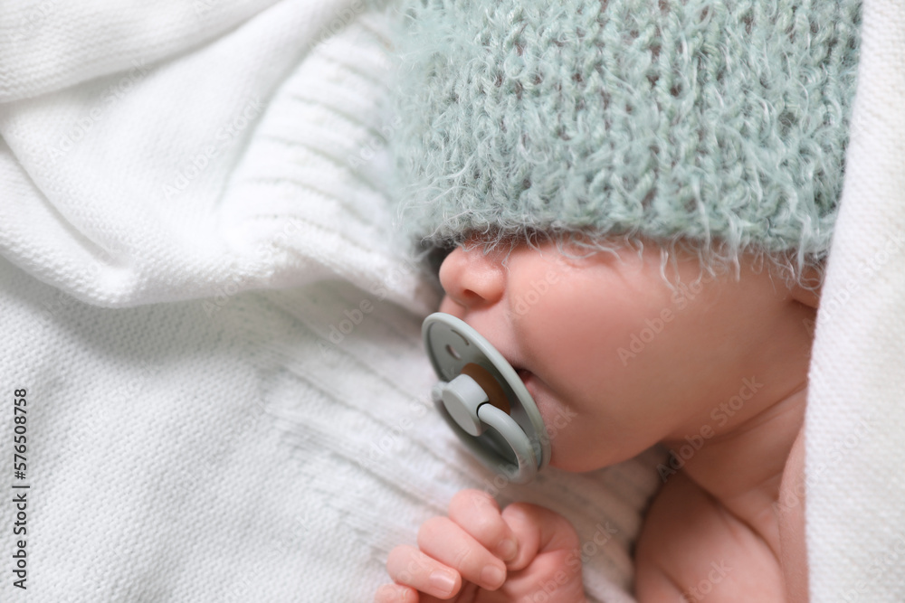 Fototapeta premium Cute newborn baby with pacifier sleeping on white blanket, top view