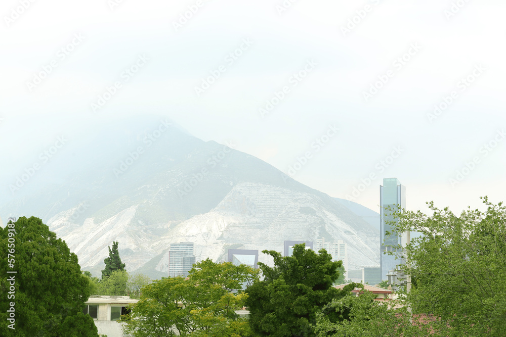 Obraz premium Picturesque view of city with buildings and trees near mountains