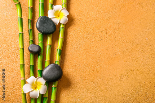 Spa stones  flowers and bamboo on beige background  top view