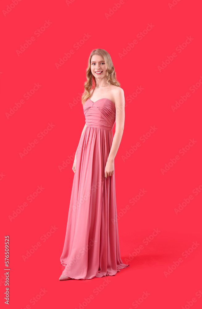Teenage girl in pink prom dress on red background Teenage girl in pink prom dress on red background