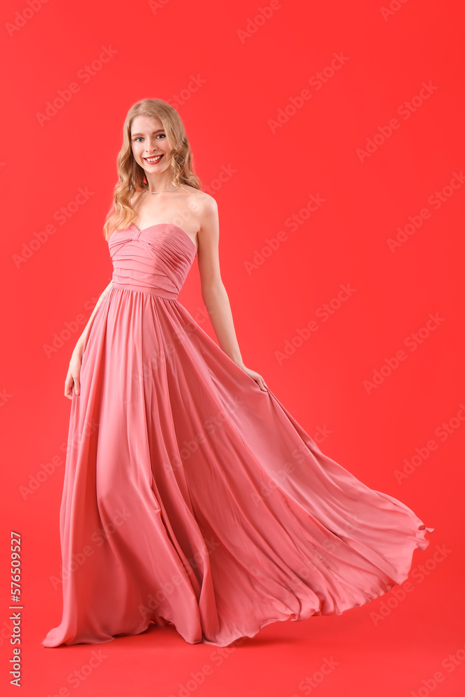 Teenage girl in pink prom dress on red background Teenage girl in pink prom dress on red background