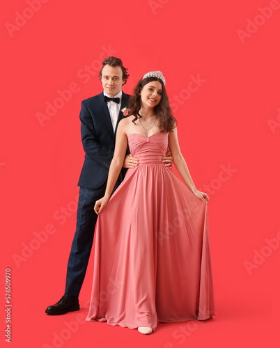 Beautiful couple dressed for prom on red background