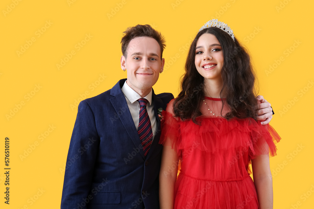Beautiful couple dressed for prom on yellow background Beautiful couple dressed for prom on yellow background