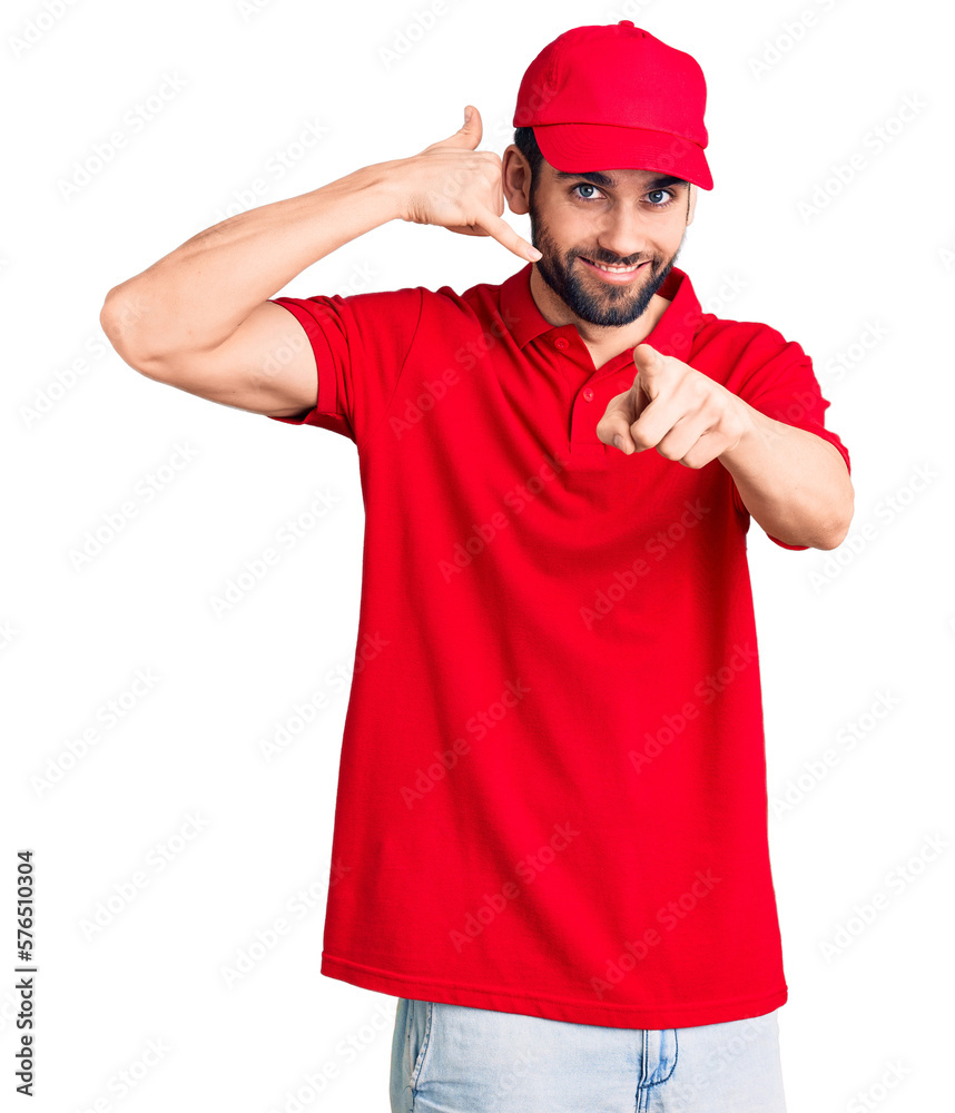 Young handsome man with beard wearing delivery uniform smiling doing talking on the telephone gesture and pointing to you. call me. Young handsome man with beard wearing delivery uniform smiling doing talking on the telephone gesture and pointing to you. call me.